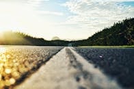 Serene road stretching through lush landscape during sunset in Kangar, Malaysia.